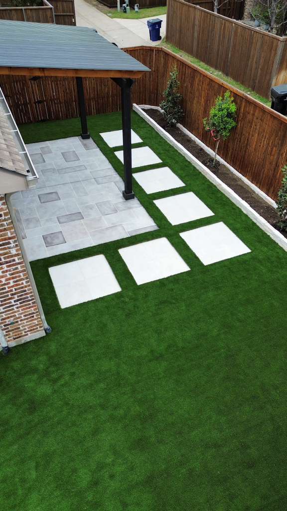 Artificial turf with concrete pavers and covered patio by ProBuild Construction in North Texas